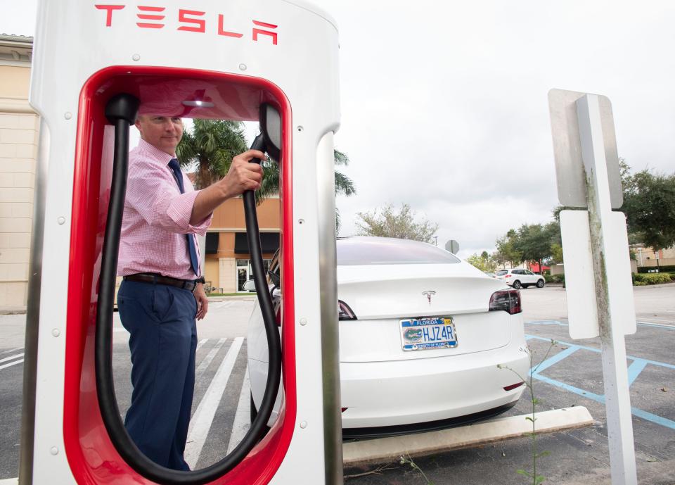 "This is an affordable, very convenient car," said Evan Berry, of Port St. Lucie, who charges his Tesla Model 3 on Wednesday, Oct. 23, 2019, at a Tesla charging station in Port St. Lucie. Berry says the electric vehicle has added $20-$30 on his home electric bill, which he considers a savings from the $300 he used to spend on gas monthly. 