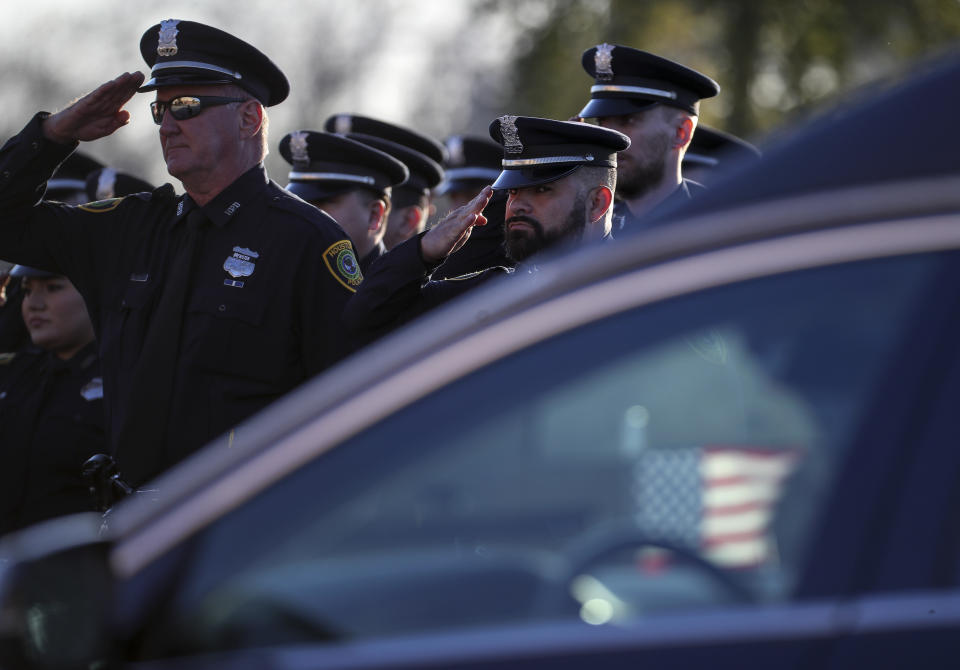Members of Houston Police Eastside Patrol Division salute as the casket carrying Houston police Sgt. Christopher Brewster arrives, Thursday, Dec. 12, 2019, at Grace Church Houston in Houston. Brewster, 32, was gunned down Saturday evening, Dec. 7, while responding to a domestic violence call in Magnolia Park. Police arrested 25-year-old Arturo Solis that night in the shooting death. Solis faces capital murder charges. (Jon Shapley/Houston Chronicle via AP)