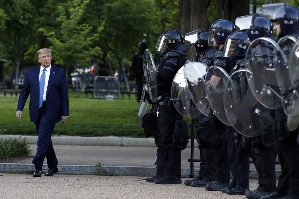 FILE - In this June 1, 2020 file photo, President Donald Trump walks past police in Lafayette Park after he visited outside St. John's Church across from the White House in Washington. An internal investigation has determined that the decision to clear racial justice protestors from an area in front of the White House last summer was not influenced by then-President Donald Trump’s plans for a photo opportunity at that spot. The report released Wednesday by the Department of Interior’s Inspector General concludes that the protestors were cleared by U.S. Park Police on June 1 of last year so new fencing could be installed. (AP Photo/Patrick Semansky)