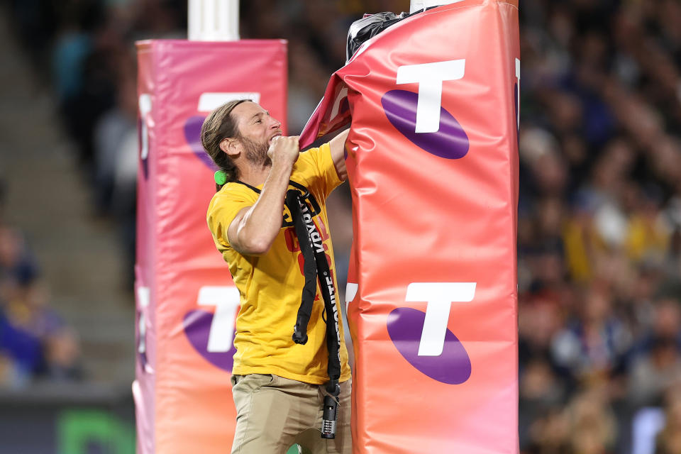 The pitch invader (pictured) pulling down the padding at the 2022 NRL Grand Final match.