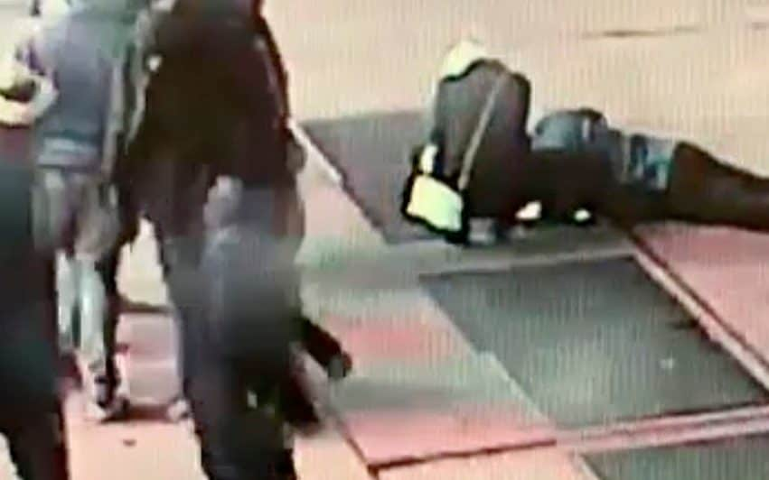 A man tries to see the engagement ring that he dropped down a utility grate on New York's Times Square - New York City Police Department