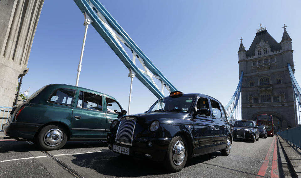 Taxis drive slowly in protest across Tower Bridge in London, Monday, July 23, 2012. The traditional London taxis were holding a protest against not being allowed to drive in the Olympic Lanes once they come into force on Wednesday, July 25. (AP Photo/Kirsty Wigglesworth)