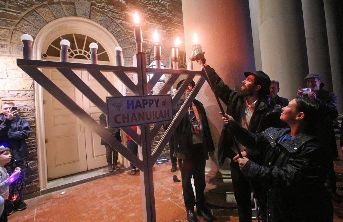 Sarah Strent, president of Chabad of Penn State, lights a 6 foot tall public Jewish Hanukkah menorah Sunday on the fourth night of the eight-day Festival of Lights, hosted by Chabad of Penn State, at Old Main.