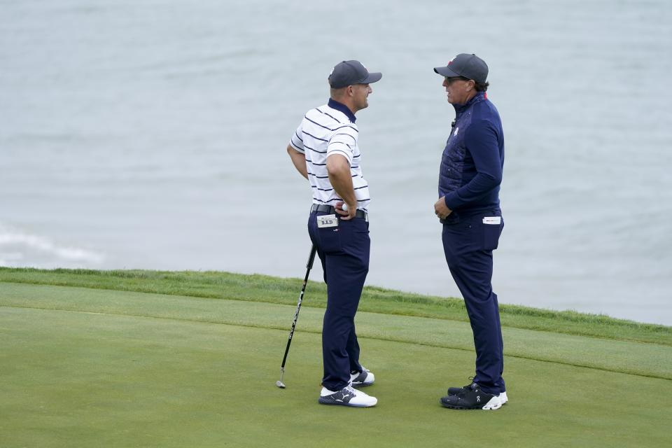 Team USA's Bryson DeChambeau talks to Phil Mickelson on the third hole during a practice day at the Ryder Cup at the Whistling Straits Golf Course Tuesday, Sept. 21, 2021, in Sheboygan, Wis. (AP Photo/Charlie Neibergall)