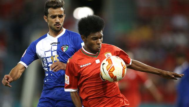 Faisal Alenezi of Kuwait contests the ball with Raed Saleh of Oman.