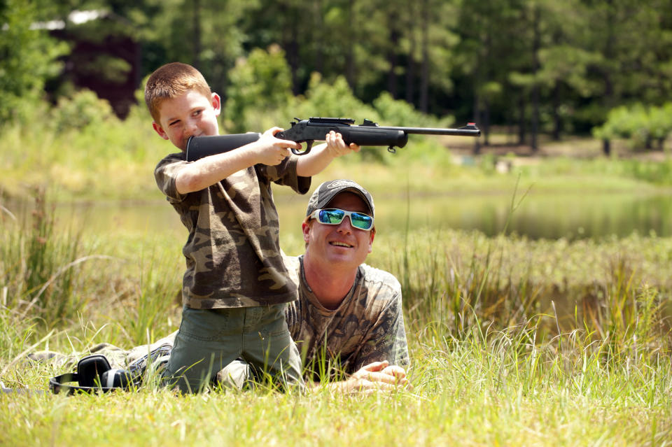 Chavez helps his son with target practice before a wild hog hunt at Great Southern Outdoors Wildlife Plantation in Union Springs