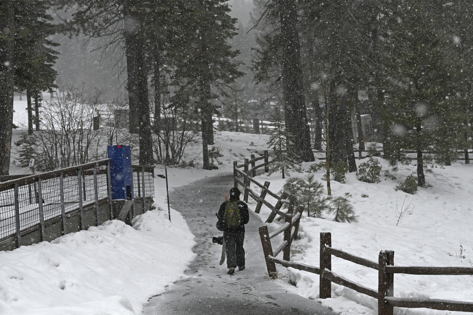 A snowboarder makes his way out of the North Star California Resort after a day of snowboarding on Thursday, Feb. 29, 2024, in Truckee, Calif. The most powerful Pacific storm of the season started barreling into the Sierra Nevada on Thursday, packing multiple feet of snow and dangerous winds that forecasters say will create blizzard conditions likely to close major highways and trigger power outages into the weekend.(AP Photo/Andy Barron)