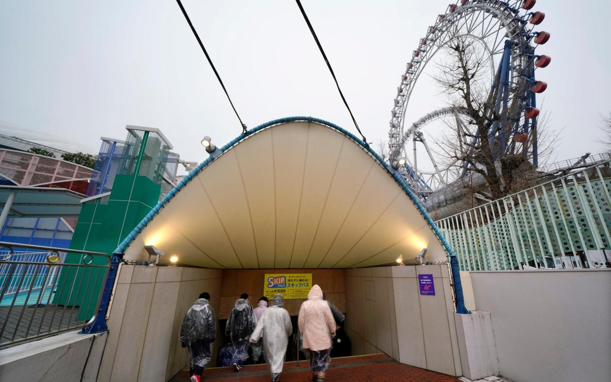 Participants take refuge underground during an evacuation drill simulating a North Korea ballistic missile attack in Tokyo, Monday - AP