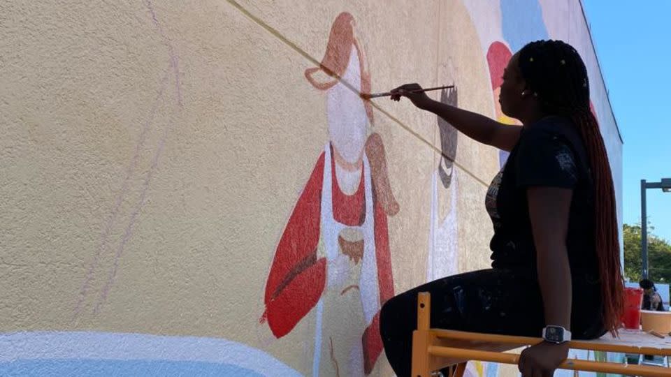 Marie Saint-Cyr painting a mural at SIBSPlace in 2023 in Rockville Centre, New York. - Courtesy Saint-Cyr Art Studio
