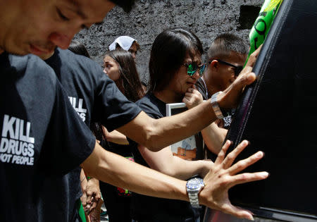 Rachelle Bermoy, widow of Eric Quintinita Sison, holds a picture of him during a funeral procession in Pasay city, metro Manila, Philippines August 31, 2016. REUTERS/Cesar Danzel