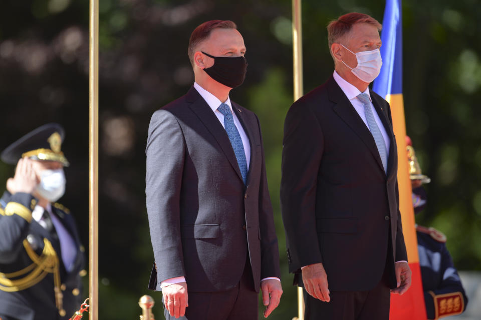 Polish President Andrzej Duda, left, stands with Romanian President Klaus Iohannis during the welcoming ceremony at the Cotroceni presidential palace in Bucharest, Romania, Monday, May 10, 2021. (AP Photo/Alexandru Dobre)