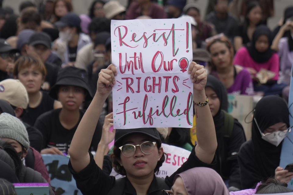 An activist holds up a poster during an International Women's Day rally in Jakarta, Indonesia, Friday, March 8, 2024. Hundreds of people took to the streets Friday in Indonesia's capital to mark International Women's Day by voicing concern over the state of democracy in the country. (AP Photo/Dita Alangkara)