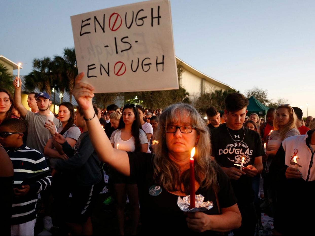 Mourners stand during a candlelight vigil for the victims of Marjory Stoneman Douglas High School shooting in Parkland, Florida on 15 February 2018: RHONA WISE/AFP/Getty Images