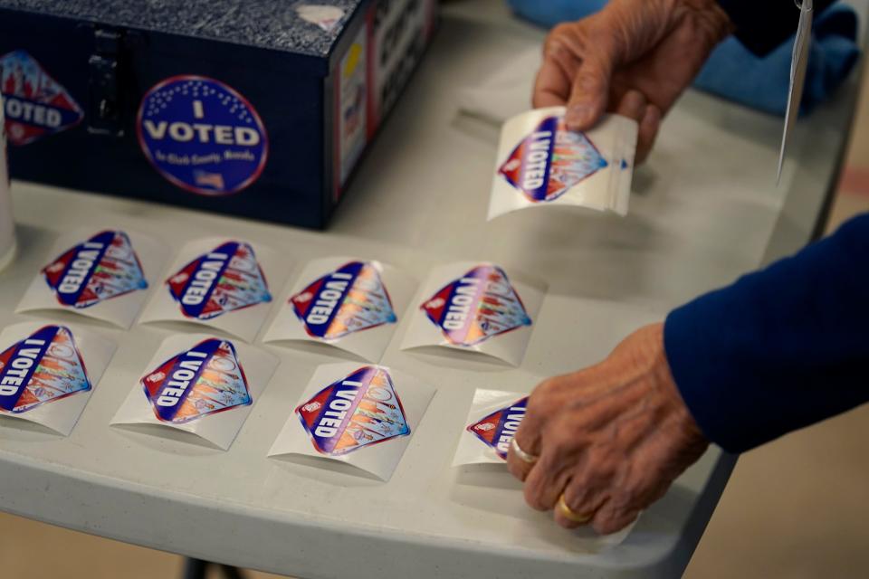 A pole worker lays out "I Voted" stickers at a polling place Tuesday, June 14, 2022, in Las Vegas.