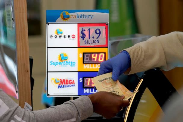 PHOTO: A customer is handed Powerball tickets purchased at Lichine's Liquor & Deli in Sacramento, Calif., Monday, Nov. 7, 2022. (Rich Pedroncelli/AP)