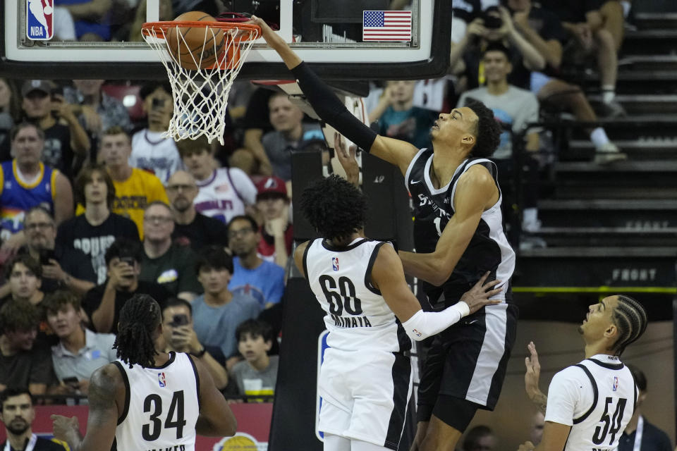 San Antonio Spurs' Victor Wembanyama dunks over Portland Trail Blazers' Justin Minaya during the first half of an NBA summer league basketball game Sunday, July 9, 2023, in Las Vegas. (AP Photo/John Locher)