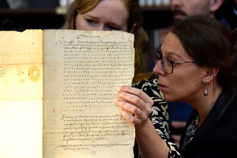 Researcher at the French National Institute for Computer Science Research (INRIA) Cecile Pierrot (L) and senior lecturer in modern history Camille Desenclos (R) look at an encrypted letter from Charles V, known as Charles Quint, the Holy Roman Emperor and Archduke of Austria, dated back to 1547, at the Stanislas library in Nancy, northeastern France, on November 23, 2022. - Researchers in computer science, a cryptographer and a historian decrypted the letter from Charles V dating back to the 16th century. (Photo by Jean-Christophe Verhaegen / AFP)