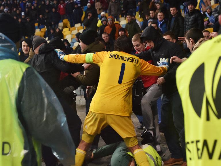 Dynamo Kiev's goalkeeper Oleksandr Shovkovskiy tries to prevent his supporters from fighting with security guards during the UEFA Europa League match against Guingamp on February 26, 2015