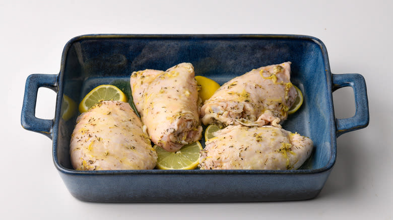 raw lemon marinated chicken thighsin baking pan