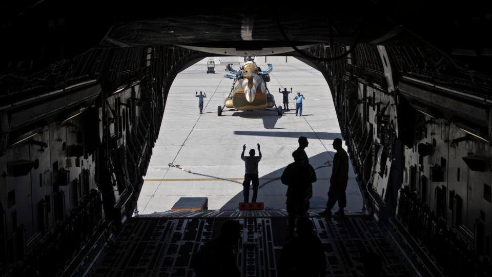 An Mi-17 helicopter is loaded on to a C-17 Globemaster III aircraft at Davis-Monthan Air Force Base, Ariz., on June 9, 2022. The C-17 was carrying a helicopter for deliver to aid Ukraine. (Airman 1st Class Paige Weldon/U.S. Air Force)