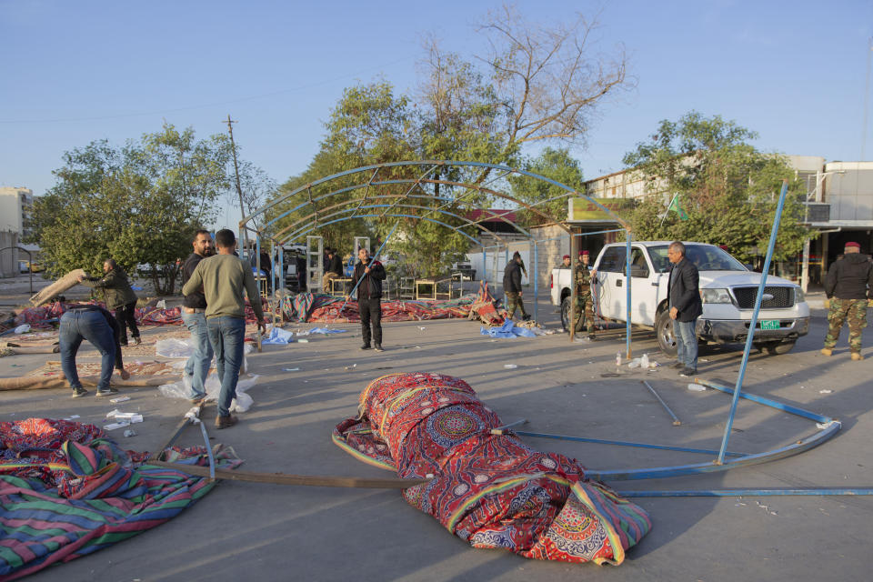 Pro-Iranian militiamen and their supporters dismantle a tent in front of the U.S. embassy, in Baghdad, Iraq, Wednesday, Jan. 1, 2020. U.S. troops fired tear gas on Wednesday to disperse pro-Iran protesters who were gathered outside the U.S. Embassy compound in Baghdad for a second day. (AP Photo/Nasser Nasser)