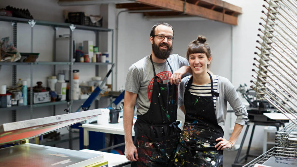 Young couple smiling in a commercial kitchen.