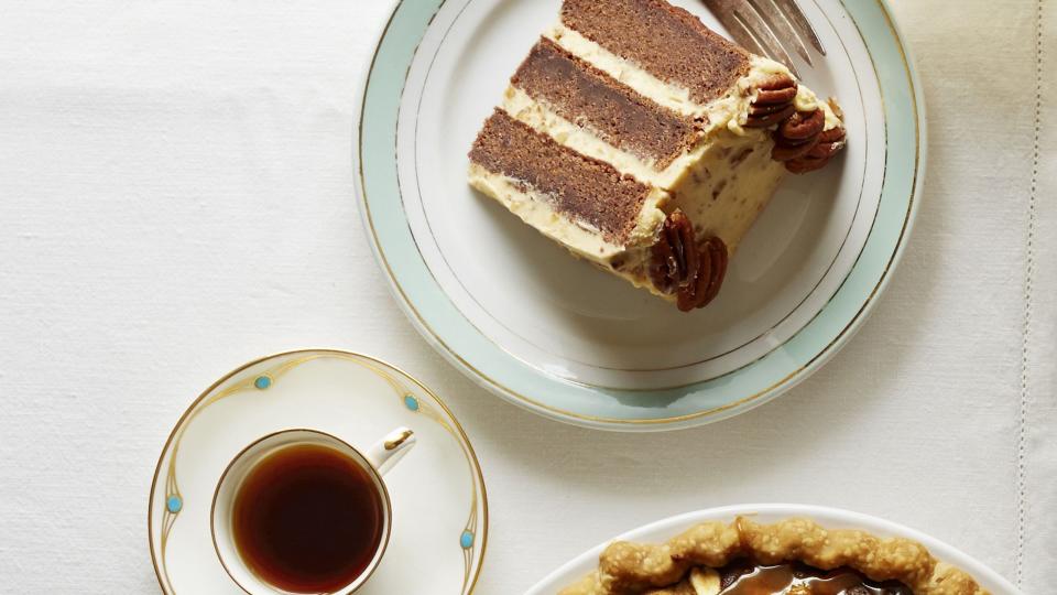 salted caramel peanut butter fudge pie in a white pie plate with small cups of coffee or tea