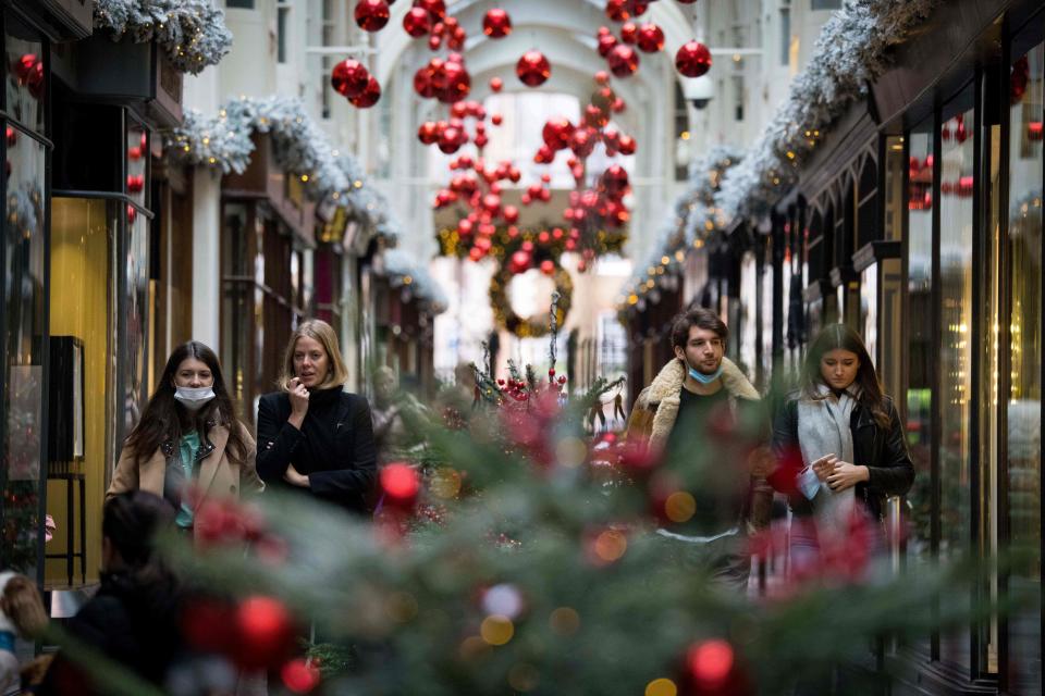 Pedestrians wearing face masks due to the COVID-19 pandemic, walk past Christmas-themed window displays inside Burlington Arcade in central London, on November 23, 2020. - Prime Minister Boris Johnson's latest plan is to roll out mass testing to the hardest-hit areas, hoping to make enough inroads to be able to relax social restrictions in time for Christmas. (Photo by Tolga Akmen / AFP) (Photo by TOLGA AKMEN/AFP via Getty Images)