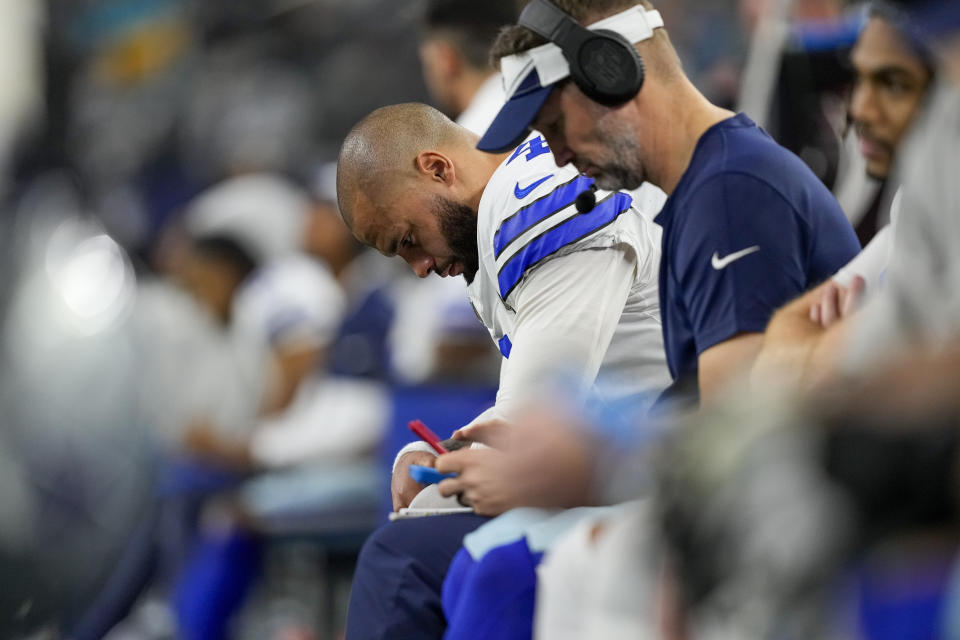 Dallas Cowboys quarterback Dak Prescott hangs his head while sitting on the bench during the second half of an NFL football game against the Green Bay Packers, Sunday, Jan. 14, 2024, in Arlington, Texas. (AP Photo/Sam Hodde)