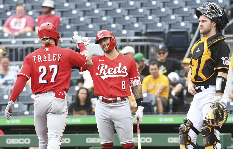 Cincinnati Reds teammates Jake Fraley (27) and Jonathan India (6) celebrate Fraley's leadoff home run near Pittsburgh Pirates catcher Jason Delay, right, during the first inning of a baseball game, Sunday, Aug. 21, 2022, in Pittsburgh. (AP Photo/Philip G. Pavely)