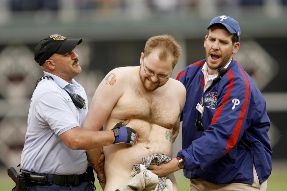 A fan who ran on the field is escorted off by security during a game between the Philadelphia Phillies and the Milwaukee Brewers on May 17, 2007 at Citizens Bank Park in Philadelphia, Pennsylvania. The Brewers won 3-2. (Photo by Rob Tringali/Sportschrome/Getty Images)