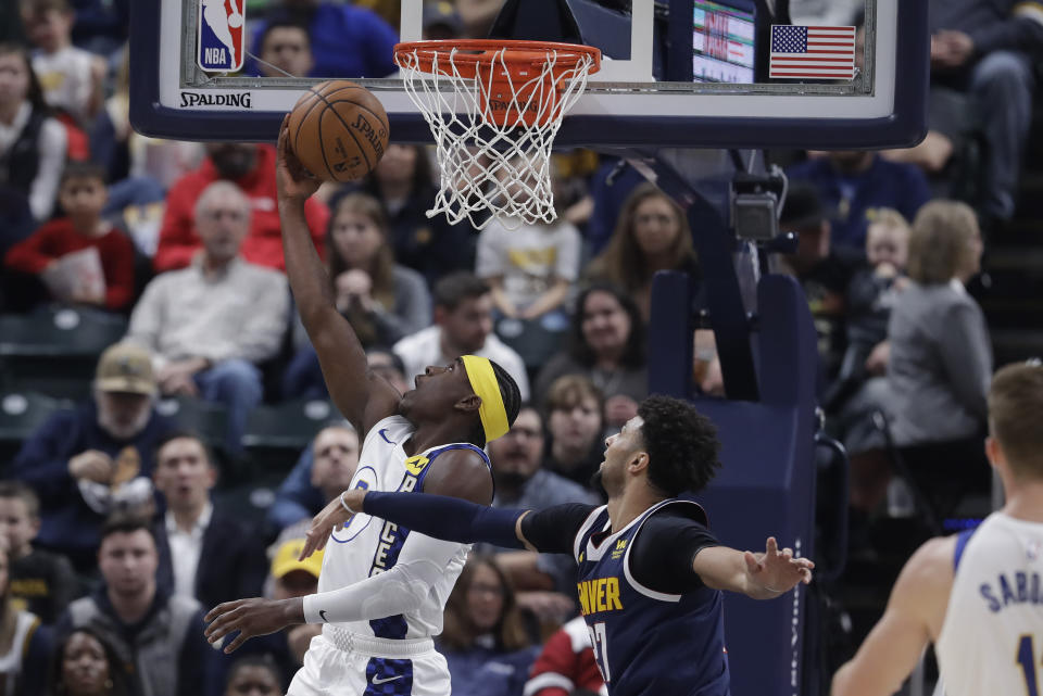 Indiana Pacers' Aaron Holiday (3) shoots next to Denver Nuggets' Jamal Murray (27) during the first half of an NBA basketball game Thursday, Jan. 2, 2020, in Indianapolis. (AP Photo/Darron Cummings)