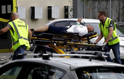 Ambulance staff take an injured man from outside a mosque in central Christchurch (AP Photo/Mark Baker)