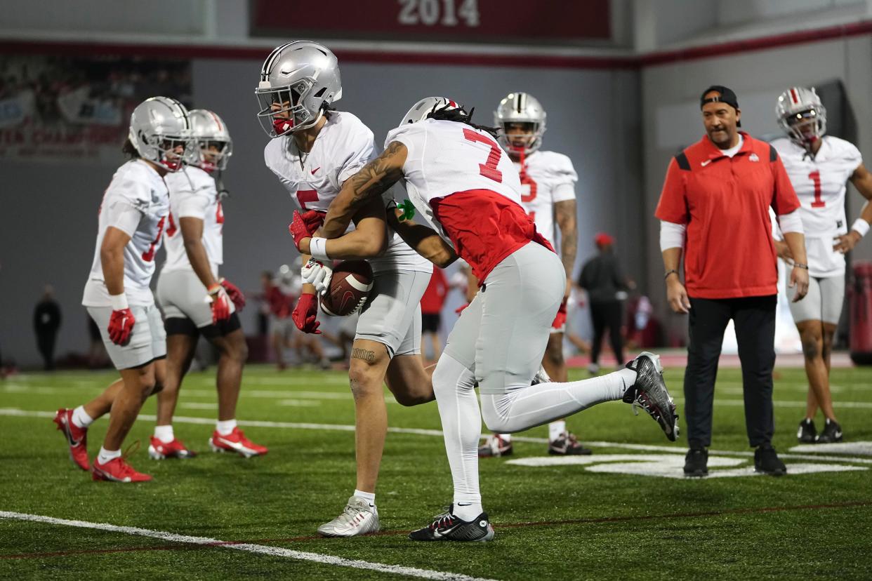 Mar 7, 2024; Columbus, OH, USA; Ohio State Buckeyes cornerback Jordan Hancock (7) tries to strip a ball from Ohio State Buckeyes cornerback Aaron Scott Jr. (5) during spring football practice at the Woody Hayes Athletic Center.