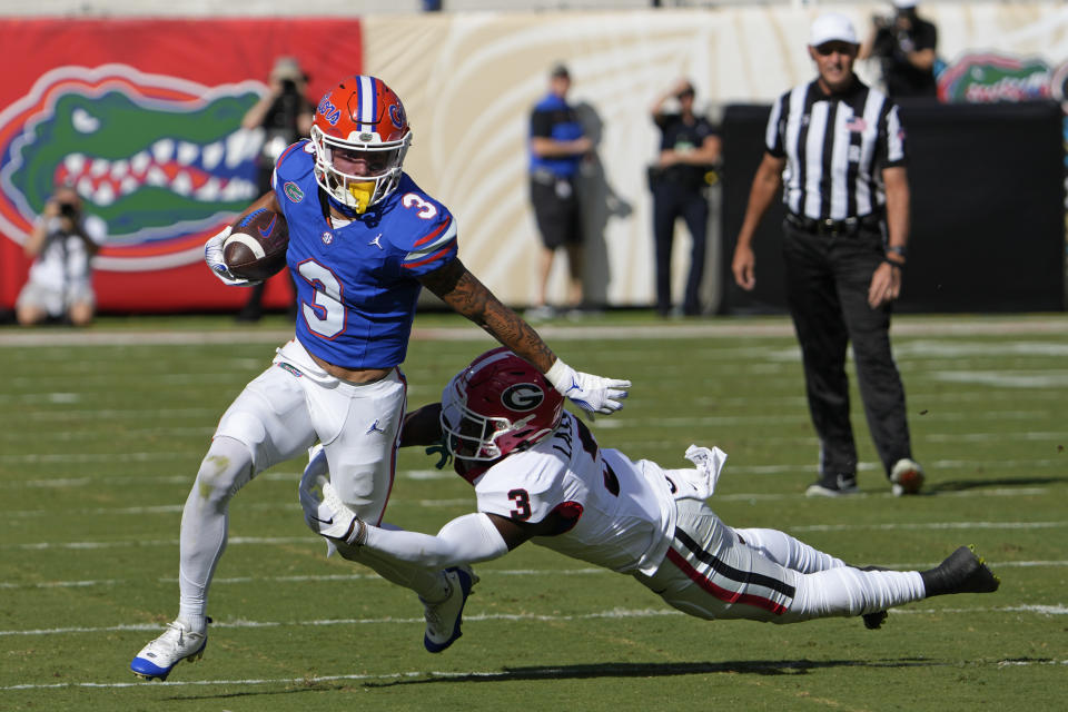 Florida wide receiver Eugene Wilson III, left, tries to get past Georgia defensive back Kamari Lassiter during the first half of an NCAA college football game, Saturday, Oct. 28, 2023, in Jacksonville, Fla. (AP Photo/John Raoux)