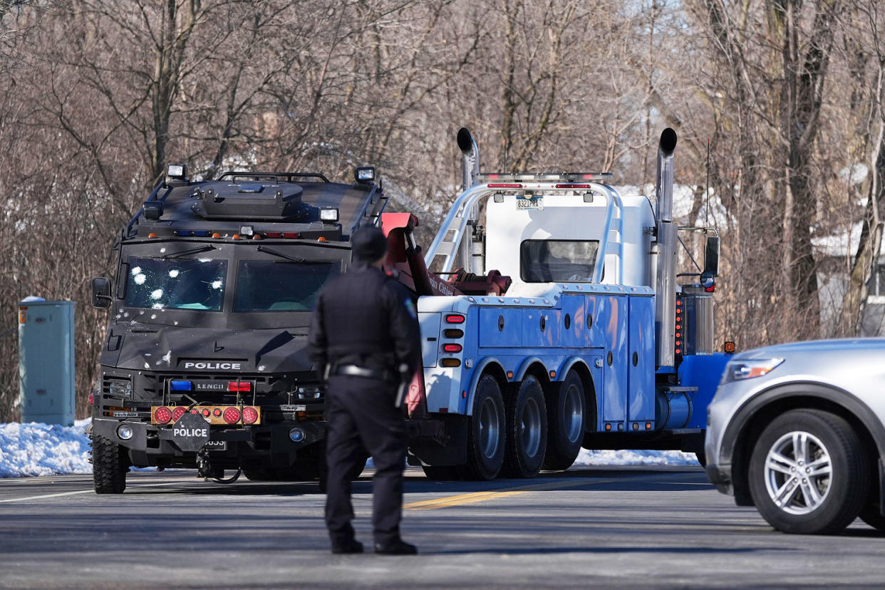 A police vehicle with what appears to be bullet pockmarks is towed away. (Abbie Parr / AP)