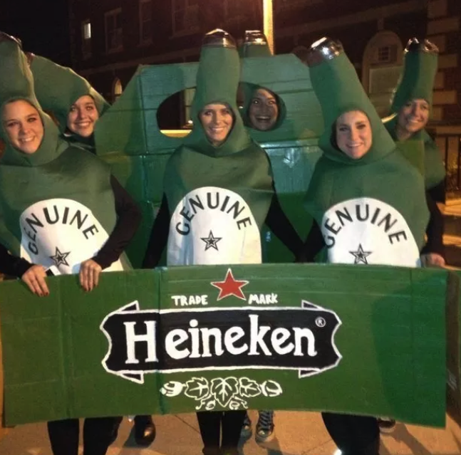 Six friends dressed as giant bottles of green Heineken bottles