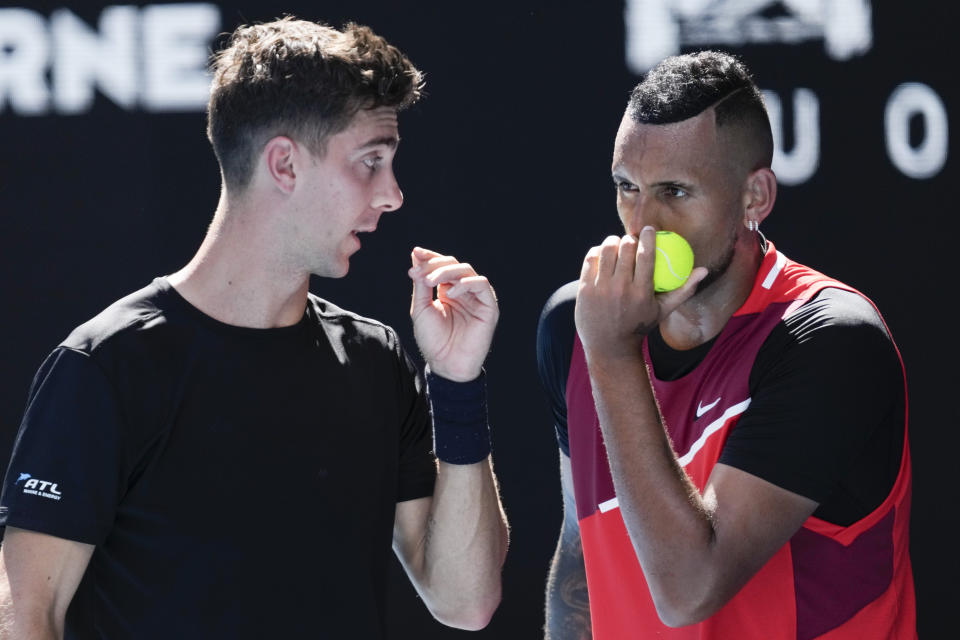 Nick Kyrgios, right, of Australia and compatriot Thanasi Kokkinakis talk during their doubles semifinal game against Marcel Granollers of Spain and Horacio Zeballos of Argentina at the Australian Open tennis championships in Melbourne, Australia, Thursday, Jan. 27, 2022. (AP Photo/Simon Baker)