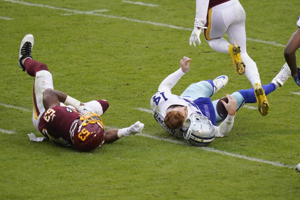 Dallas Cowboys quarterback Andy Dalton's (14) helmet comes off after getting hit by Washington Football Team inside linebacker Jon Bostic (53) in the second half of an NFL football game, Sunday, Oct. 25, 2020, in Landover, Md. Dalton left the field after this hit and Bostic was ejected from the game. (AP Photo/Patrick Semansky)