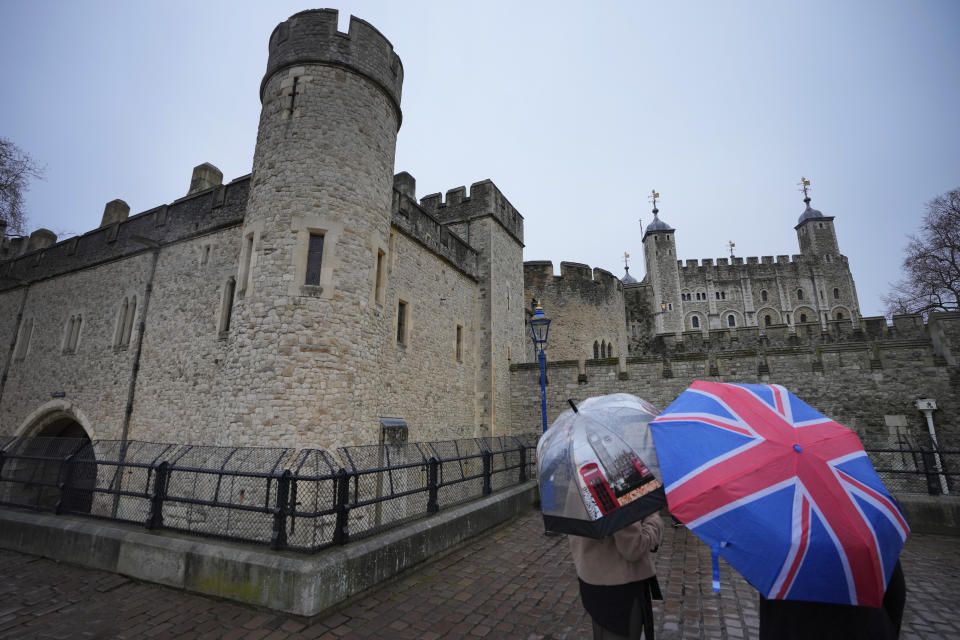 Tourists shelter under umbrellas as they view The Tower of London in London, Thursday, Feb. 29, 2024. (AP Photo/Kirsty Wigglesworth)