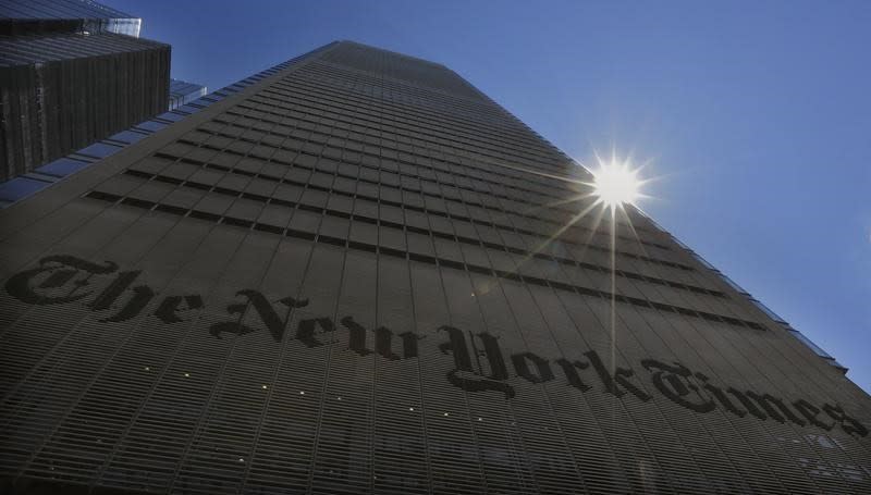 The sun peaks over the New York Times Building in New York August 14, 2013. REUTERS/Brendan McDermid