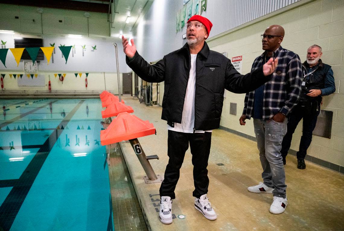 Comedian Jo Koy, left, and his brother-in-law, Andre Simmons, talk about how much they disliked their mandatory swimming classes when they were students at Foss High School while on a tour at the school in Tacoma, Wash. on Nov. 29, 2022. Koy presented a check for $30,000 to the Foss Scholarship Fund that will be dedicated to Foss students going into the arts. He also donated a framed poster from his movie “Easter Sunday”, a framed cover of Variety magazine and a microphone.