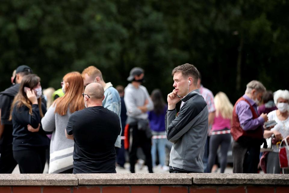People queue near the Crown and Anchor pub following a spike in cases of the coronavirus disease (REUTERS)