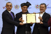 FILE - In this Feb. 19, 2020, file photo, first Vice President Amrullah Saleh, left, President Ashraf Ghani, and second Vice President Sarwar Danish, and show the official certificate of winning a second term in the presidential election to Ghani, during ceremony in Kabul, Afghanistan. A roadside bomb went off in the Afghan capital on Wednesday, Sept. 9, killing two civilians — an attack that targeted the country's first vice president, his spokesman said.(AP Photo/Rahmat Gul)