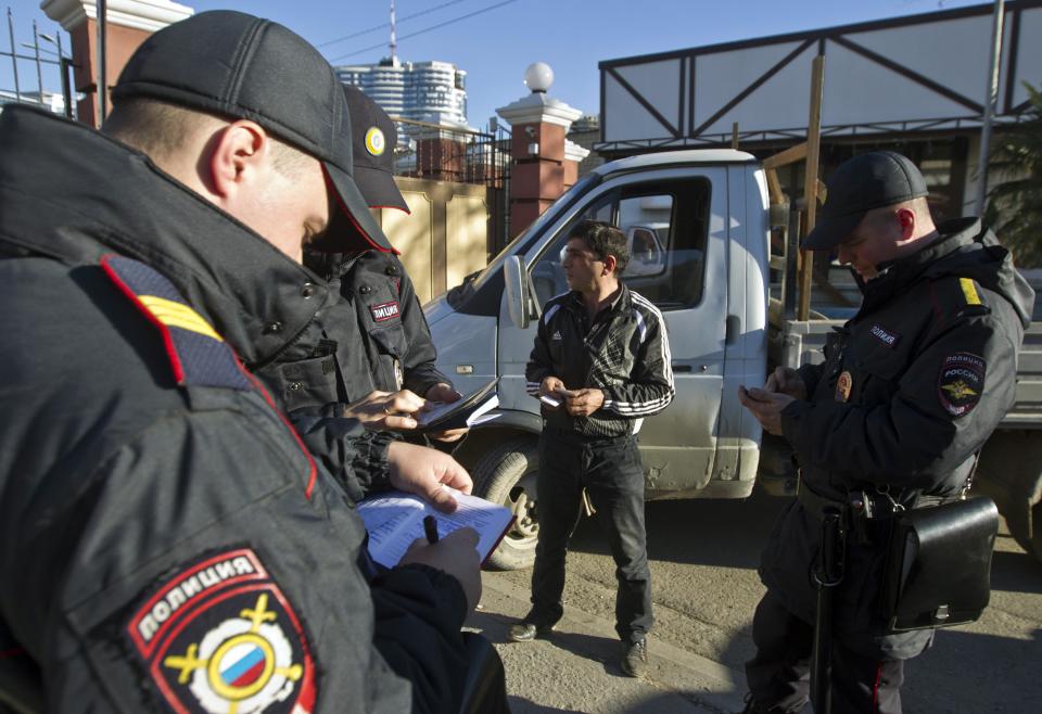 Russian police check a driver's documents in Sochi December 30, 2013. The International Olympic Committee has no doubt Russian authorities will be able to provide security at the Winter Olympics, a spokeswoman said on Monday after two bomb blasts killed tens of people in the Russian city of Volgograd. REUTERS/Maxim Shemetov (RUSSIA - Tags: SPORT OLYMPICS CRIME LAW CIVIL UNREST)