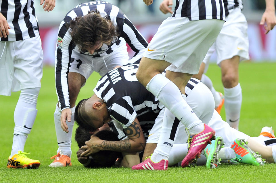 Juventus defender Kwadwo Asamoah, of Ghana, on the ground, is celebrated by his teammates after scoring during a Serie A soccer match between Juventus and Chievo Verona, at the Juventus stadium, in Turin, Italy, Sunday, Feb. 16, 2014. (AP Photo/Massimo Pinca)