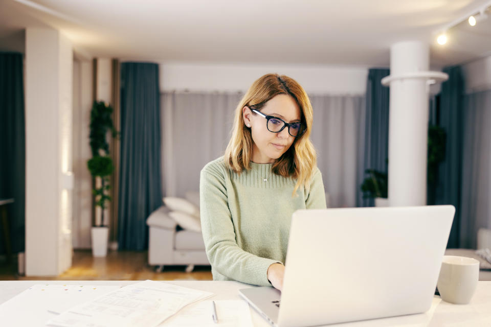 A middle-aged woman working from home on laptop.