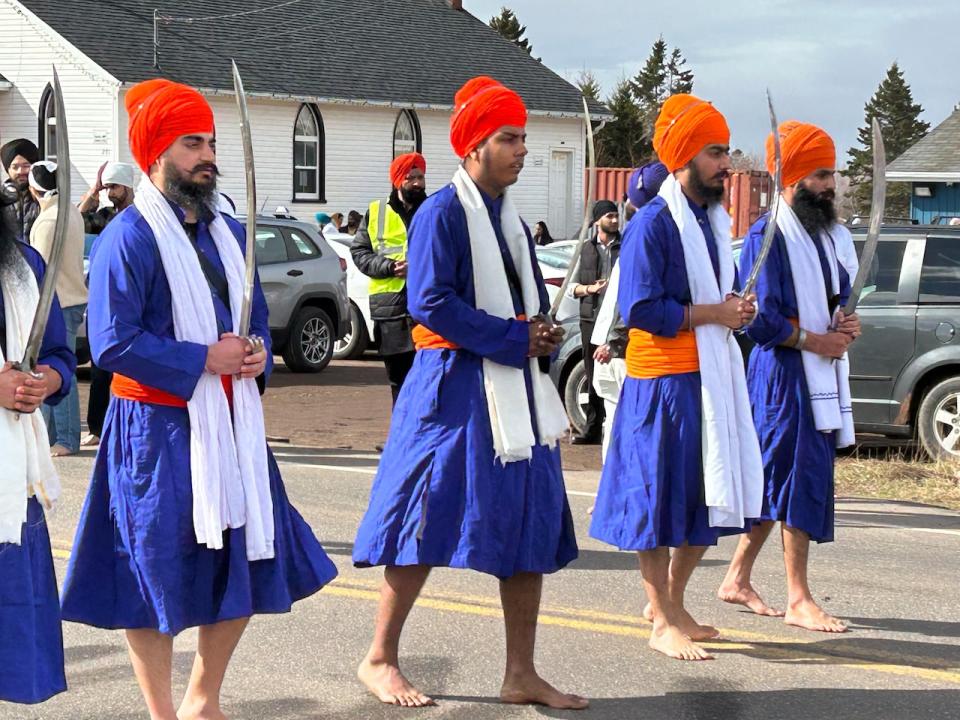 Men in blue robes march in a procession known as Nagar Kirtan in Charlottetown on Sunday. (Stacey Janzer/CBC - image credit)