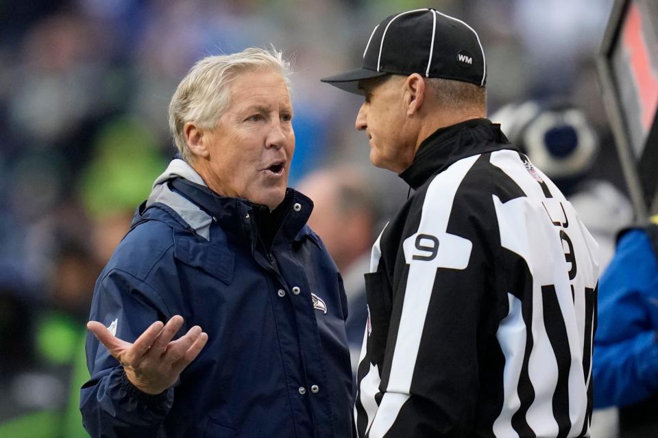 Seattle Seahawks head coach Pete Carroll speaks with line judge Mark Perlman (9) during the first half of an NFL football game against the Carolina Panthers, Sunday, Dec. 11, 2022, in Seattle. (AP Photo/Gregory Bull)