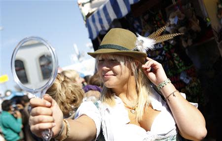 Sophia Traeger tries on a hat at Munich's 180th Oktoberfest October 3, 2013. REUTERS/Michaela Rehle